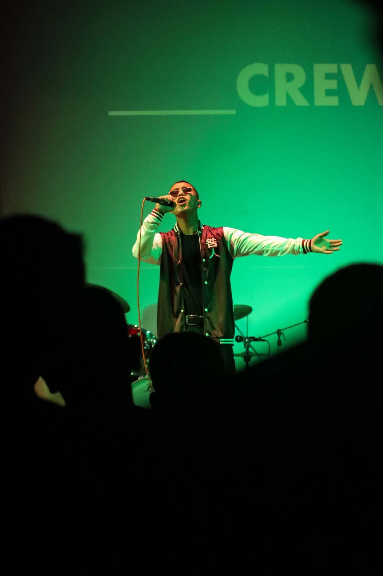 Live solo concert performance under green stage lights